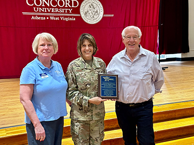 Image with Maj Gen (Ret) Kim Crider (holding a plaque), Col (Ret) Peter Jones, Col (Ret) Linda McMahon